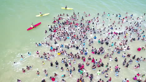 Drohnenaufnahme-Von-Großen-Menschenmengen-Im-Ozean-In-Durban-Südafrika-Mit-Rettungsschwimmern,-Die-Die-Menschen-Schützen