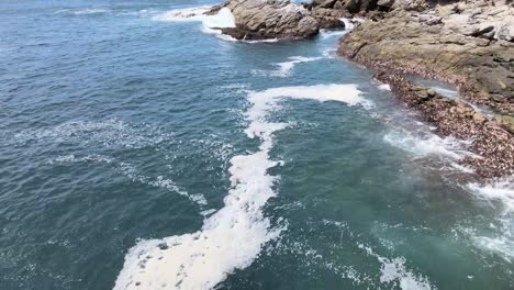 Pull-back-above-rocks-and-waves-in-Oaxaca,-Mexico