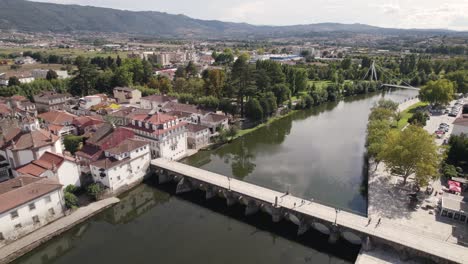 Aerial-forward-view-of-river-with-its-Romanic-bridge-in-city