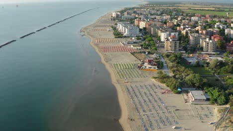 Aerial-view-of-sandy-beach-with-umbrellas,gazebos-and-town
