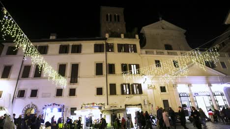 People-walking-at-night-in-Rome,-Italy-with-church-and-steeple-in-background-with-an-establishing-video-shot