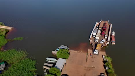 Aerial-view-of-cars-and-trucks-disembarking-from-a-ferry-in-the-city-of-Carolina,-State-of-Maranhão,-Brazil