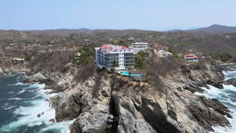 Orbit-right-to-left-around-cliffs-and-small-hotel-in-Oaxaca,-Mexico