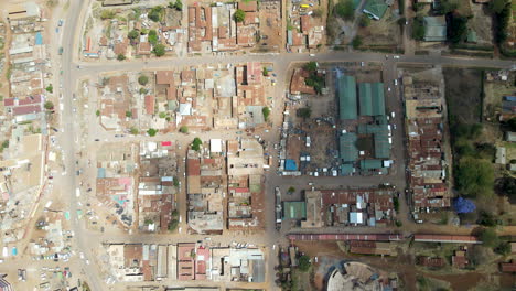 Top-down-view-of-slums-and-industrial-buildings-in-busy-African-town,-drone-slowly-rising-up