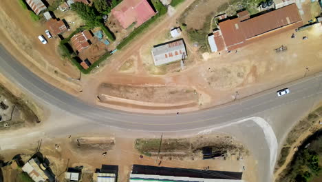 Top-down-view-of-cars-driving-over-road-in-a-small-town-in-Kenya