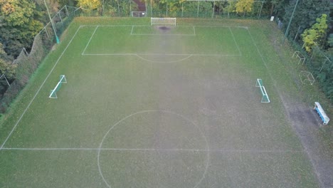 Luftaufnahmen-Von-Drohnen-Eines-Fußballspielplatzes,-Umgeben-Von-Herbstbäumen