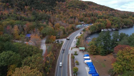 Aerial-View,-Lakeside-Road-by-Lake-Sunapee-and-Newbury-New-Hampshire-USA-at-Fall-Peak,-Cars-and-Lakefront-Houses