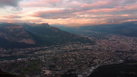Aerial-time-lapse-of-Grenoble-city-surrounded-by-alps-mountains-during-cloudy-sunset