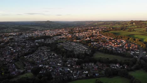 Aerial-forward-shot-overlooking-Honiton-in-Devon-at-sunset-with-the-Blackdown-Hills-in-the-background