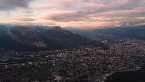 Vista-Aérea-De-La-Ciudad-De-Grenoble-En-Las-Montañas-De-Los-Alpes-De-Francia-Durante-La-épica-Puesta-De-Sol,-Destino-De-Vacaciones