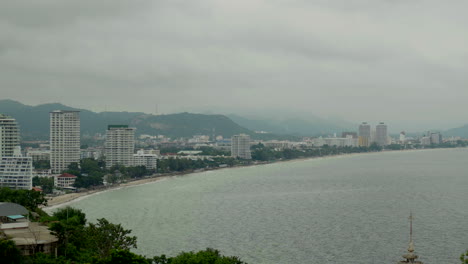 An-establishing-shot-of-the-Hua-Hin-Bay-on-a-gloomy-overcast-rainy-day-during-monsoon-season,-the-bay-lined-with-luxury-hotels-and-a-popular-local-travel-destination-in-Thailand