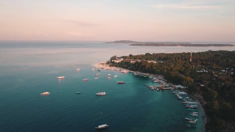 Flying-high-over-tropical-Island-Gili-air-looking-over-the-coastline-and-Gili-Trawangan-in-the-discance,-at-sunset-in-4k