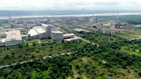 Ajaokuta-Steel-Company-in-the-Kogi-State,-Nigeria-along-the-river-and-mountains---aerial-view