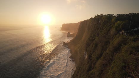 Static-colourful-sunset-shot-of-waves-coming-in-on-the-high-cliffs-of-Nusa-Penida,-Indonesia-in-4k