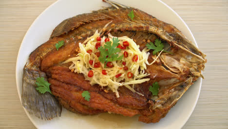 Fried-Sea-Bass-Fish-with-Fish-Sauce-and-Spicy-Salad-on-plate