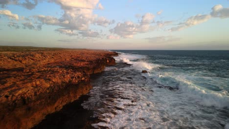 Drone-flying-above-clifftops-along-the-Western-Australian-coast-line-at-sunset