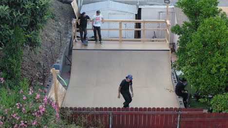 Jóvenes-Patinadores-Montando-En-La-Rampa-Del-Patio-Trasero-Haciendo-Trucos,-Vista-Aérea