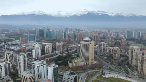 órbita-Aérea-Alrededor-De-La-Rotonda-Principal-Con-Rascacielos-En-Santiago,-Chile-Con-Las-Montañas-De-Los-Andes-En-La-Parte-Posterior