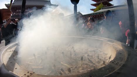 Menschen-Winken-Im-Rauch-Eines-Räuchergefäßes-In-Einem-Tempel-In-Tokio,-Japan