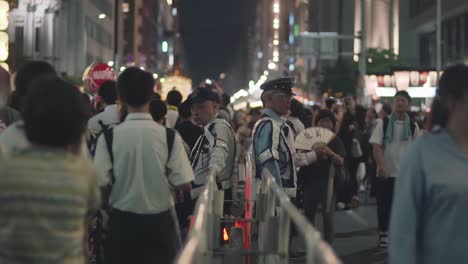 Japanische-Polizisten-In-Blinkenden-Westen-Beobachten-Die-Menge-Während-Des-Gion-Matsuri-Festivals-In-Kyoto,-Japan---Mittlere-Aufnahme