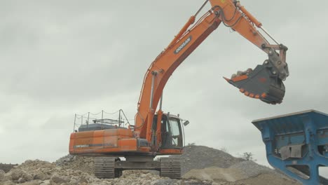 Bagger-Mit-Großem-Eimer-Nimmt-Stein-Auf,-Der-Den-Steinbruch-Füllt