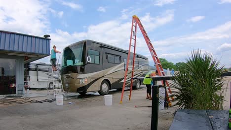 Woman-on-a-ladder-working-at-RV-detailing-small-business