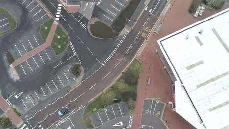 Aerial-view-birds-eye-forward-urban-shopping-centre-empty-parking-spaces-closed-COVID-virus-town-lock-down