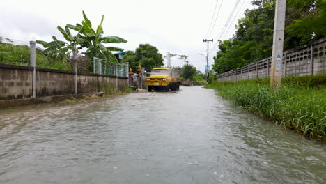 Ein-Mann,-Der-Nach-Einem-Monsunsturm-In-Einer-überfluteten-Straße-Schlamm-Von-Seinem-Lastwagen-Wäscht