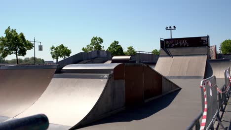 Forced-closure-of-Skate-Park-Colbert-during-the-COVID-19-pandemic-no-trespassing-tape-waves-in-wind,-Stable-handheld-shot