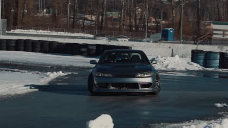 Captura-De-Seguimiento-De-Un-Rápido-Nissan-Silvia-A-La-Deriva-En-Una-Pista-Mojada-Durante-Un-Soleado-Día-De-Invierno