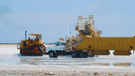 Camiones-Circulando-Por-El-Salar-En-Kralendijk,-Bonaire-Para-Cargar-Sal---Plano-Medio