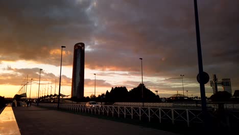 Sunset-Timelapse-of-Seville-Landscape-with-Torre-Pelli,-Cars,-and-People