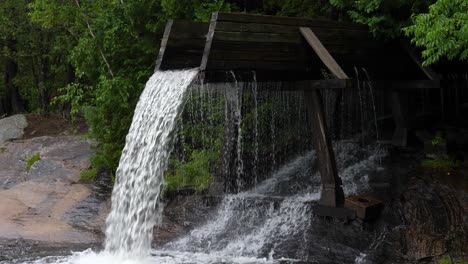 Crooked-Slide-Park,-Combermere-Ontario---Wasser-In-Zeitlupe-Mit-60-Bildern-Pro-Sekunde,-Das-Im-Sommer-Von-Einer-Alten-Baumstammrutsche-Fällt