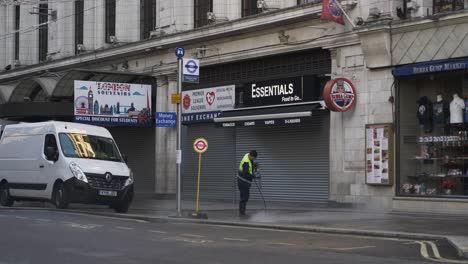 Trabajador-Limpiando-La-Acera-Con-Chorro-De-Agua-A-Alta-Presión-Durante-El-Cierre