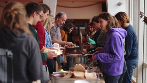 Teilnehmer,-Die-Sich-Während-Der-Jugendkonferenz-In-Der-Waldorfschule-Niederlande-Zum-Mittagessen-In-Einer-Schulkantine-Anstellen---Mittlere-Aufnahme