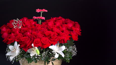 Rote-Rosen-Und-Lilienkorb-Mit-Lotus--Und-Gerbera-Dekorationsschieber-Erschossen-Schwarzen-Hintergrund