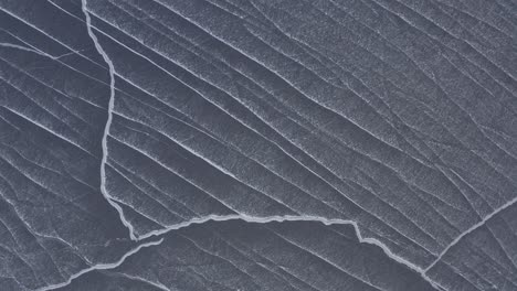 Abstrakte-Schneeverwehungslinien-Auf-Dem-Aufsteigenden-Luftbild-Des-Eissees