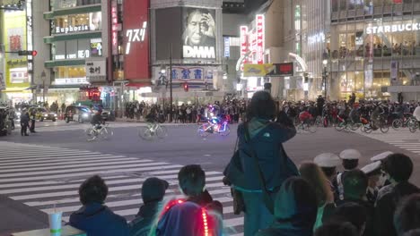 La-Multitud-Llena-Los-Bordes-De-Las-Carreteras,-Viendo-A-Un-Complicado-Ciclista-Pasar-Por-El-Cruce-De-Shibuya-En-La-Noche-De-Halloween-En-Tokio,-Japón---Hiperlapso