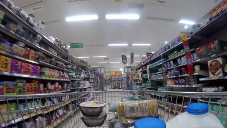 Inside-supermarket-shopping-cart-pushing-trolley-down-flour-aisle-as-customers-shop-during-corona-virus-pandemic