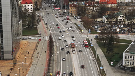 Drone-footage-of-Porsche-sports-cars-driving-in-busy-city-street,-Lithuania