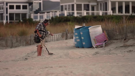 Mann-Mittleren-Alters-Sieben-Sand-Mit-Metalldetektor-Am-Strand