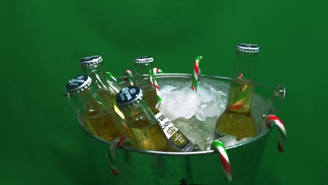 1-2-rotating-green-screen-metalic-bucket-of-beer-iced-with-candy-canes-hanging-in-six-pack-of-refreshing-golden-corona-extra-coronita-207-milileter-capped-bottles-ready-to-quench-your-festive-thirst