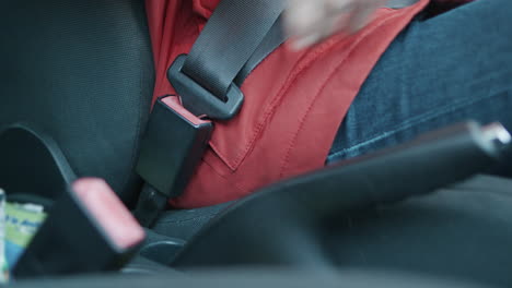 Man-with-Red-Coat-Buckling-up-in-a-Car-with-Seat-Belt-for-Human-Safety-and-Accident-Prevention-in-slowmo