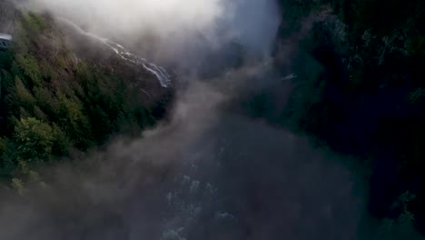 Mystische-Luftaufnahme-Einer-Wunderschönen-Schlucht-Mit-Nebel-Und-Sonnenlicht-Im-Tal