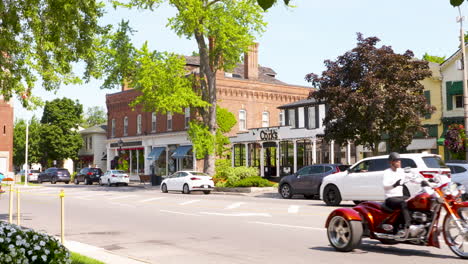 Motorcycles-ride-down-the-street-in-scenic-Niagara-on-the-Lake,-Ontario