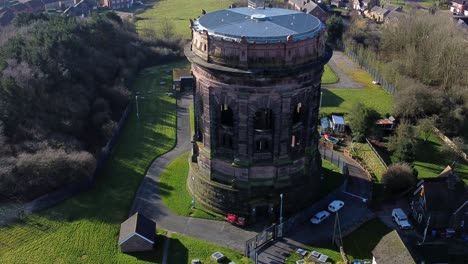 Aerial-view-National-trust-Norton-historical-water-tower-landmark-Runcorn-England-rural-scene-slow-rising-shot