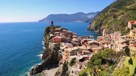Static-view-overlooking-Vernazza-coastline,-harbor-and-bay-with-colorful-houses-and-turquoise-water-on-a-sunny-summer-day-in-Vernazza,-Cinque-Terre,-Liguria-Italy