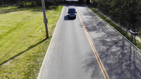 Amazon-delivery-van-drives-down-city-road---aerial-drone