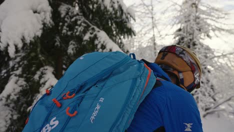 Close-up-to-a-wide-shot-of-man-skiing-with-dog-in-snow-forest