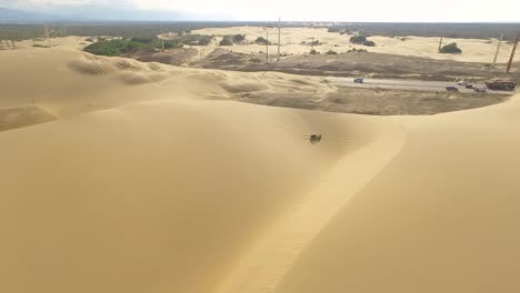 Drone-shot-of-a-Boogie-car-jumping-the-sand-dunes-in-Medanos-de-Coro,-Falcon,-Venezuela